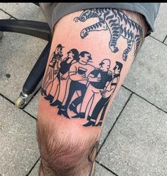 a man with a tiger tattoo on his leg next to some people and a bike