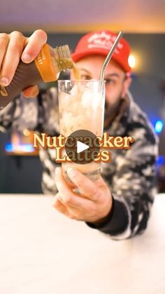 a man holding a glass filled with ice and some sort of substance next to him