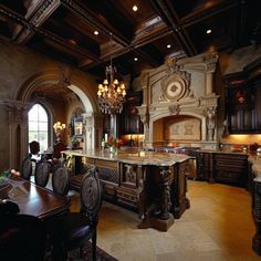 an ornate kitchen with chandelier, marble counter tops and large island in the center