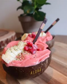 two bananas and raspberry ice cream in a coconut shell on a wooden table