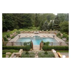 an aerial view of a pool surrounded by hedges