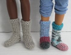 two dolls standing next to each other wearing knitted socks and leg warmers,