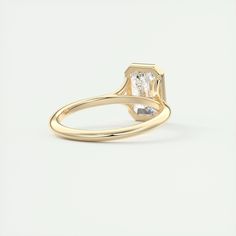 a yellow gold ring with an oval cut diamond in the center, on a white background