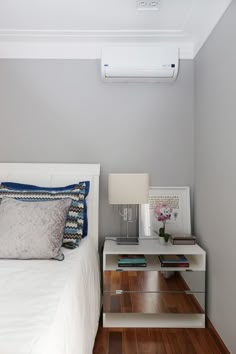 a bedroom with a bed, nightstand and air conditioner