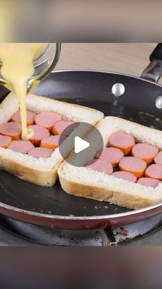 someone is pouring mustard on some food in a frying pan with hotdogs