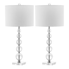 two clear glass table lamps with white shades