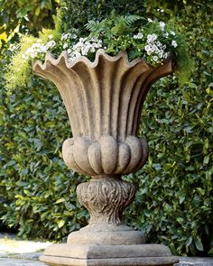 a stone planter with white flowers in it