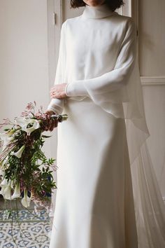 a woman in a white dress holding a bouquet