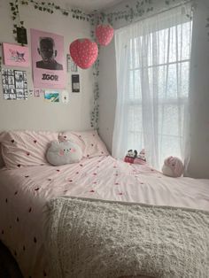 a bedroom with pink and white decorations on the walls, bedding and window sill