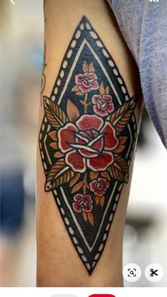 an image of a tattoo on someone's arm that has flowers and leaves on it