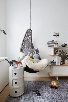 a bedroom with a hammock hanging from the ceiling and toys on the floor