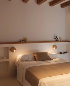 a large bed sitting in the middle of a bedroom next to a wall mounted shelf