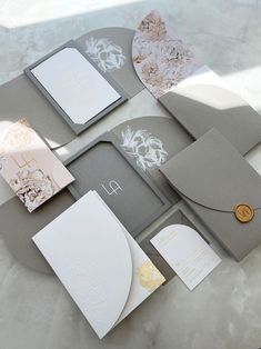 the wedding stationery is laid out on top of each other, including cards and envelopes