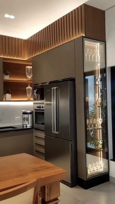 a modern kitchen with stainless steel appliances and wood accents on the walls, along with an island