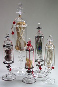 several glass vases filled with different types of items