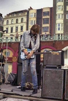 a man standing on top of a stage with a guitar in front of his face