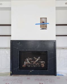 an empty room with a fireplace in the middle