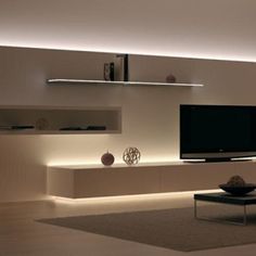 a living room filled with furniture and a flat screen tv on top of a wall