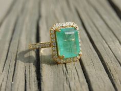 18k Emerald Cut Natural Emerald Diamond Ring - Women 18K Gold Gift Ring - 4.70 Carat Emerald Ring - Perfect Engagement Gift - May Birthstone GEMSTONE DETAILS : ✦ Gemstone : Natural Zambia Emerald ✦ Gemstone Size : 8.50 width and 10 mm length ✦ Gemstone Shape : Emerald Cut ✦ Number of Gemstones : 1 ✦ Gemstone Weight : 4.70 Carat ✦ Gemstone Grade : AAA DIAMOND DETAILS : ✦ Diamond Type : Natural ✦ Diamond Size : 1.70 mm and 1.5 mm ✦ Diamond Color : G-H ✦ Diamond Clarity : Slightly included ✦ Diamon Emerald Ring With Pave Setting For Gift, Emerald Wedding Jewelry With Pave Setting, Gold Emerald Ring With Pave Setting As Gift, Gold Emerald Rings With Pave Setting, Gold Emerald Ring With Pave Setting For Wedding, Gold Emerald Cut Gemstones For Wedding, Gold Emerald Cut Ring With Pave Setting, Wedding Emerald Ring With Pave Setting In 14k Gold, Exquisite Emerald Ring With Pave Setting For Wedding