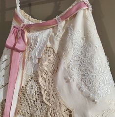 an old dress with pink ribbon and lace on it