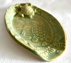 a small turtle is sitting on top of a green plate that has writing on it