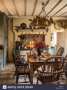 an old fashioned kitchen with wooden chairs and a table in the center - stock photo