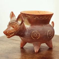 a ceramic animal shaped vase sitting on top of a wooden table