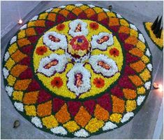 a flower arrangement on the ground with candles