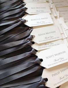 black and white business cards are lined up on top of each other with ribbons attached to them