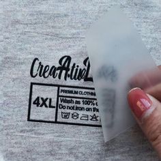 a person holding up a piece of paper with an ad for clothing on the back