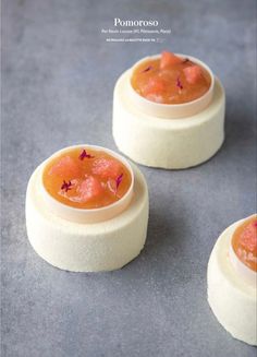 three small cakes with orange sauce in them