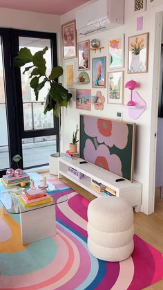 a living room with colorful rugs and pictures on the wall