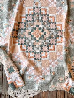 an old quilt is laying on top of a doily next to a lace doily