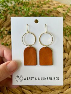 These earrings measure approximately 3/4" wide x 2 1/3" drop (including hook). Made with hypoallergenic 14k gold plated hooks and silicone earring backs, they're perfect for sensitive ears. These are hand crafted from from genuine leather and raw brass which makes such a beautiful combination. Each set is packaged in a brown jewelry box for easy gifting! Our current processing time is 3-5 business days. We ship USPS Ground Advantage with a Priority upgrade available at checkout; both shipping options include tracking which will be sent to you when your order ships.  Need a bulk order or have a custom request? We'd love to hear from you! Please reach out to us at aladyandalumberjack@gmail.com Love your order? We'd love to see it! Please tag us on Instagram @aladyandalumberjack. Brown Small Hoop Earrings With Ear Wire, Minimalist Brown Hoop Earrings For Everyday, Modern Small Hoop Brown Earrings, Brown Rectangular Earrings With Ear Wire, Minimalist Brown Hoop Earrings For Gift, Trendy Handmade Earrings For Everyday Use, Modern Brown Small Hoop Earrings, Everyday Brown Hoop Earrings With Ear Wire, Trendy Brown Jewelry With Ear Wire