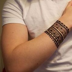 a person with a tattoo on their arm holding a cell phone and wearing a white t - shirt