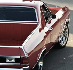 an old red car is parked on the street