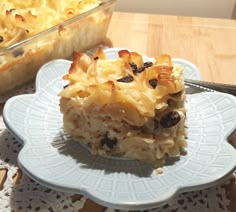 a piece of dessert sitting on top of a plate next to a casserole dish