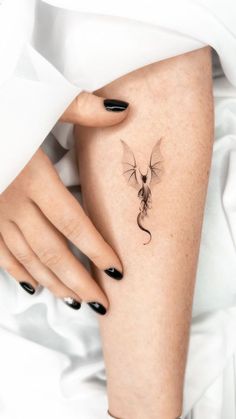 a woman's leg with a small tattoo on it