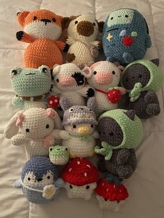 there are many crocheted stuffed animals on the bed