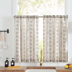 a kitchen with a sink, counter top and window curtain in it's center