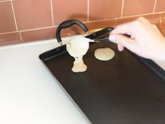 a person is making cookies on a baking sheet