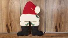 a wooden santa clause sitting on top of a wooden floor next to a wood paneled wall