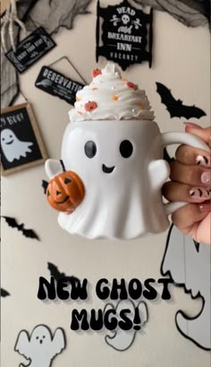 a person holding a coffee mug with a ghost on it's side and the words, new ghost mugs