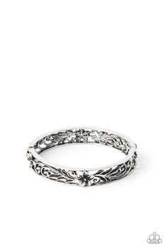 a silver ring with filigrees and flowers on the inside, set against a white background