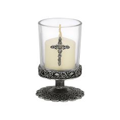 a glass candle holder with a cross on it