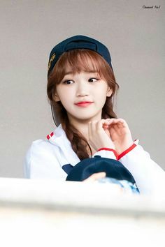 a young woman wearing a sailor's uniform and holding her hand to her chin