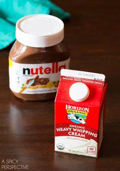 two jars of nutella sitting on top of a wooden table