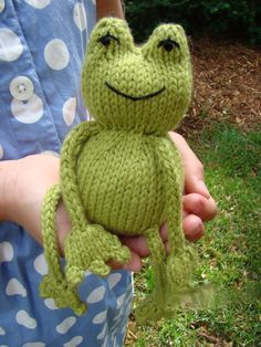 a person holding a stuffed frog in their hands