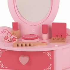 Let your little princess practice her future makeup skills with the Petite Pink Vanity by Hape. This adorable little play makeup counter includes all the accessories your child needs to look her best whether. Designed for imaginary play, the counter features everything your child could want for a makeup set. Check your look in the built-in mirror, and imagine applying powder with the wooden puffs. Brush your hair with the wooden brush and spritz a little perfume on with the pretend perfume bottle. All durably built from wood, the accessories are safe for your child's use and are finished in lovely red and pink paints. When done preparing for a pretend day at the office or an imaginary night on the town, stow away the makeup tools in the beauty counter's drawer. Safe to use and great for pl Future Makeup, Drawer Safe, Beauty Desk, Hape Toys, Pretend Makeup, Makeup Skills, Makeup Counter, Beauty Counter, Play Makeup