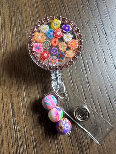 This bold bright flower badge or happy face badge reel  is showing off some fun perfect and cutesy.  These make super fun and useful gifts for any person in any profession. A great gift choice for nurses, medical staff, office staff, and anyone who is required to wear a badge. Hand made with glitter, resin, and design rhinestones rim bottle cap with resin to make it waterproof. Each design is handmade so each badge we make will look slightly different than the next.    Bead charm can be made custom if you would like different colors please message me. Colors of beads will be randomly selected if no choice is made.  Indoor and outdoor photos to show details.  TERMS AND CONDITIONS  By purchasing this item, you acknowledge that you have read the listing description in full and that you agree Rhinestone Badge Reel Diy, Novelty Pink Badge Holder For Birthday, Fun Pink Badge Reel For Gift, Cute Personalized Badge Reel For Gifts, Fun Pink Badge Holders For Gift, Personalized Cute Badge Reel For Gift, Adjustable Fun Badge Holders For Gifts, Personalized Fun Badge Reel For Gift, Handmade Fun Badge Reel For Gift